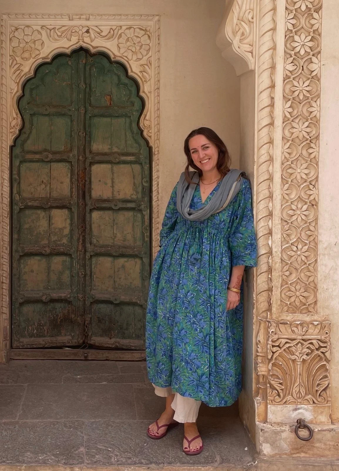Natasha Barnett standing beside a carved sandstone doorway in India